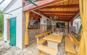 a patio with a wooden table and benches at Lovely Home In Jablanac With Wifi in Jablanac