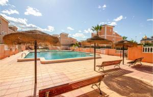 ein Pool mit zwei Bänken und Sonnenschirmen in der Unterkunft Lovely Home With Swimming Pool in Santa Pola