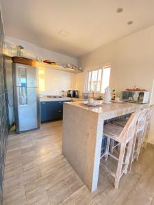 a kitchen with a large island in the middle at Casa Ibiza - Pontal do Atalaia - Arraial do Cabo in Arraial do Cabo +9 photos