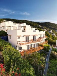 a large white building on a hill with flowers at Casa Ibiza - Pontal do Atalaia - Arraial do Cabo in Arraial do Cabo