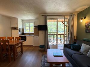 een woonkamer met een bank en een tafel bij Joli duplex pr 5p, parking, balcon, piscine été in Cauterets