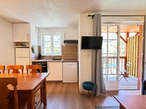 een keuken met een tafel en een eetkamer bij Joli duplex pr 5p, parking, balcon, piscine été in Cauterets +9 foto's