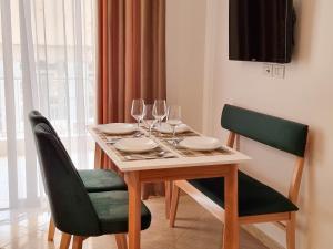a dining room table with wine glasses on it at Arte Apartment in Sarandë