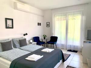 ケストヘイにあるVilla Lillybeth Garden Roomsのベッドとテーブルと椅子のある寝室