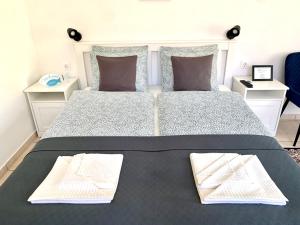 ケストヘイにあるVilla Lillybeth Garden Roomsの大きなベッドとタオル2枚のある寝室
