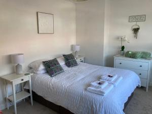 a bedroom with a bed with towels on it at Henley Town Rooms in Henley on Thames
