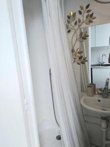 biała łazienka z umywalką i lustrem w obiekcie Studio le Métropole Centre ville w mieście Deauville