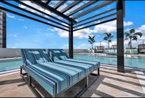 迈阿密Resort Style 1-Bdrm Apt Downtown Doral的游泳池旁天井上的长凳