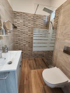 a bathroom with a toilet and a sink at Joó Apartman in Balatonszabadi
