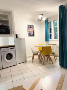 a kitchen with a washing machine and a table with chairs at T2 près de la plage et du Club House du Golf in Moliets-et-Maa