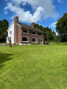 a house with a large lawn in front of it at Millbrook House in Oldcastle