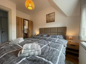Un dormitorio con una cama grande con toallas. en Zafiro 27 Kolašin, en Kolašin