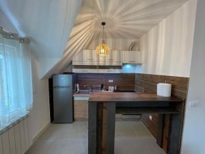 Una cocina con una mesa de madera y un refrigerador. en Zafiro 27 Kolašin, en Kolašin