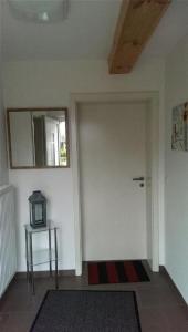 una stanza con porta bianca, tavolo e specchio di Ferienwohnung in Vorland mit Grill und Garten a Vorland