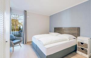 a bedroom with a bed and a chair and a window at Baltischer Hof Apartment 43 in Boltenhagen