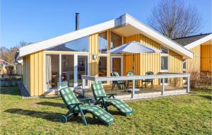 a yellow house with chairs and an umbrella at Amazing Home In Rechlin With Wifi in Rechlin