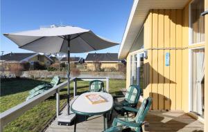 a patio with a table and chairs and an umbrella at Amazing Home In Rechlin With Wifi in Rechlin +21 photos