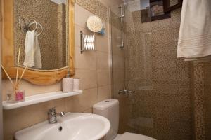 a bathroom with a toilet and a sink and a shower at Villa Electra in Halki
