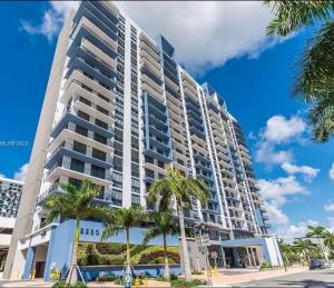迈阿密Resort Style 1-Bdrm Apt Downtown Doral的一座前面有棕榈树的高楼