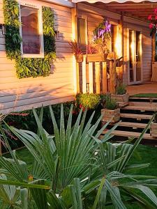 a house with some plants in front of it at Le Lagon Rose nice bungalow Camping SIBLU le Mar Estang Canet-en-Roussillon, 2 rooms, 2 bathrooms, 2 TV, free WIFI, sheets & towels included, beach at 5 mn walk in Canet-en-Roussillon