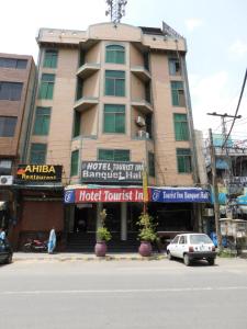 a building with a car parked in front of it at HOTEL TOURIST INN in Lahore