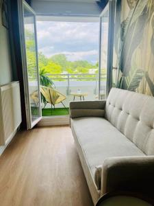 a living room with a couch and a large window at Appartement proche Paris, Disney, Cité Descartes, Centrex in Champs-Sur-Marne