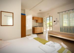 a bedroom with a large white bed and a kitchen at vila SEJUDA Alberghetto in Peschici +68 photos