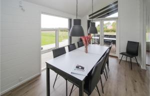 a dining room with a white table and chairs at Nice Home In Samsø With Kitchen in Nordby