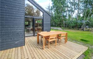 a wooden table and chairs on a wooden deck at Lovely Home In Samsø With Wifi in Nordby +17 photos
