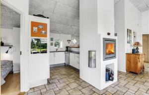 a kitchen with white cabinets and a fireplace in a room at Holiday Home Flejmose Sydals Xii in Kegnæshøj