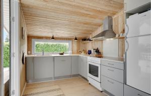 a kitchen with white cabinets and a wooden ceiling at Three-Bedroom Holiday Home In Bjert in Binderup Strand +18 photos