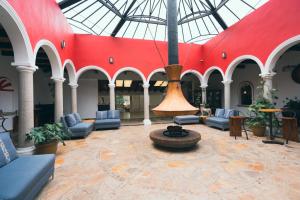 eine große Lobby mit einer großen roten Wand und einem Brunnen in der Unterkunft Hotel Villa Mercedes San Cristobal in San Cristóbal de las Casas