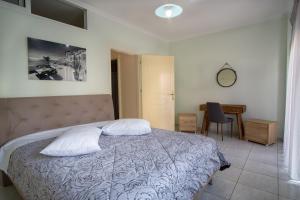 a bedroom with a bed with two pillows and a desk at Aretousa Luxury Apartment in Samos