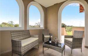 a living room with two chairs and a table and two windows at 6 Bedroom Beautiful Home In Bibbona in Bibbona +47 photos