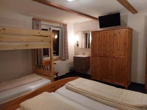 - une chambre avec 2 lits superposés et une télévision dans l'établissement Ferienwohnung Aineck in Sankt Michael im Lungau, à Sankt Michael im Lungau