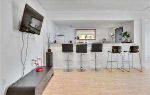 HemmetにあるHoliday Home Hemmet With Hot Tub Viのリビングルーム(スツールとテレビ付きのバー付)