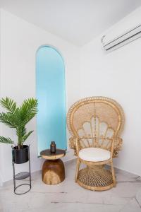 a rattan chair and a table and a plant at Ammos Luxury Suite - in der Nähe des Strandes von Faliraki in Faliraki