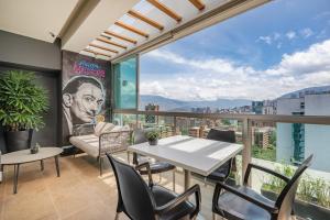 a room with a table and chairs and a large window at Affinity ApartaHotel - Extended Stay in Medellín