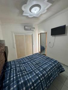a bedroom with a bed with a blue plaid blanket at Departamento Marilu in Guasave