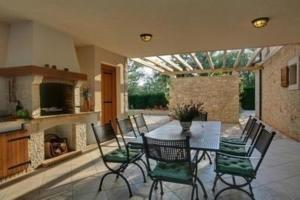 Un comedor con mesa y sillas y chimenea. en Ferienhaus in Karigador mit Terrasse, Whirlpool und Garten, en Karigador