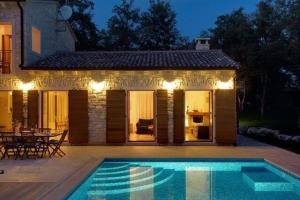una casa con piscina delante de una casa en Ferienhaus in Karigador mit Terrasse, Whirlpool und Garten, en Karigador