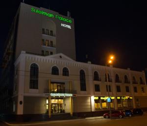 カザンにあるSuleiman Palace Hotelの夜間の看板のある建物