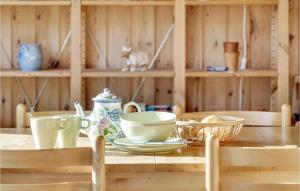 a wooden table with bowls and plates on it at Holiday Home Strandtoften Kirke Hyllinge Iii in Sæby
