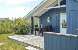 a blue house with a wooden deck with a table at Holiday Home Lakolk Iv Denmark in Bolilmark +17 photos
