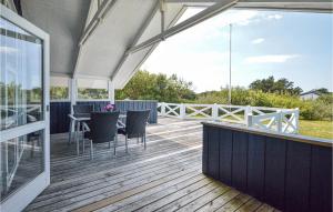 a deck with a table and chairs on it at Holiday Home Lakolk Iv Denmark in Bolilmark