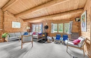 a log cabin living room with a fireplace and chairs at Four-Bedroom Holiday Home In Otterup in Otterup