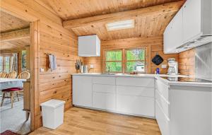 a kitchen with white cabinets and wooden walls at Four-Bedroom Holiday Home In Otterup in Otterup +10 photos