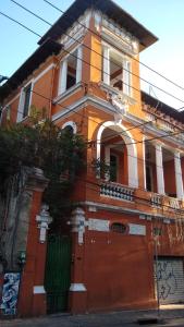 an orange building with a green door and a gate at Casa Laranja in Rio de Janeiro