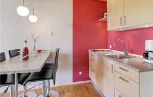阿灵厄Nice Apartment In Allinge With Wifi的厨房设有红色和白色的墙壁和柜台