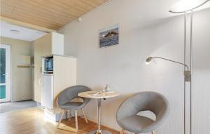 阿灵厄Nice Apartment In Allinge With Wifi的一间设有两把椅子、一张桌子和一盏灯的房间